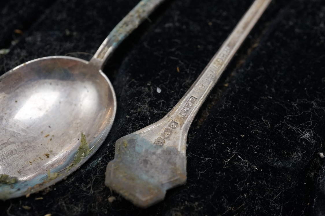 A cased set of six Elizabeth II silver teaspoons, the enamelled terminals decorated with a jockey in racing colours, maker JJW, Birmingham, 1978, together with a cased set of five (ex six) silver teaspoons and a cased se